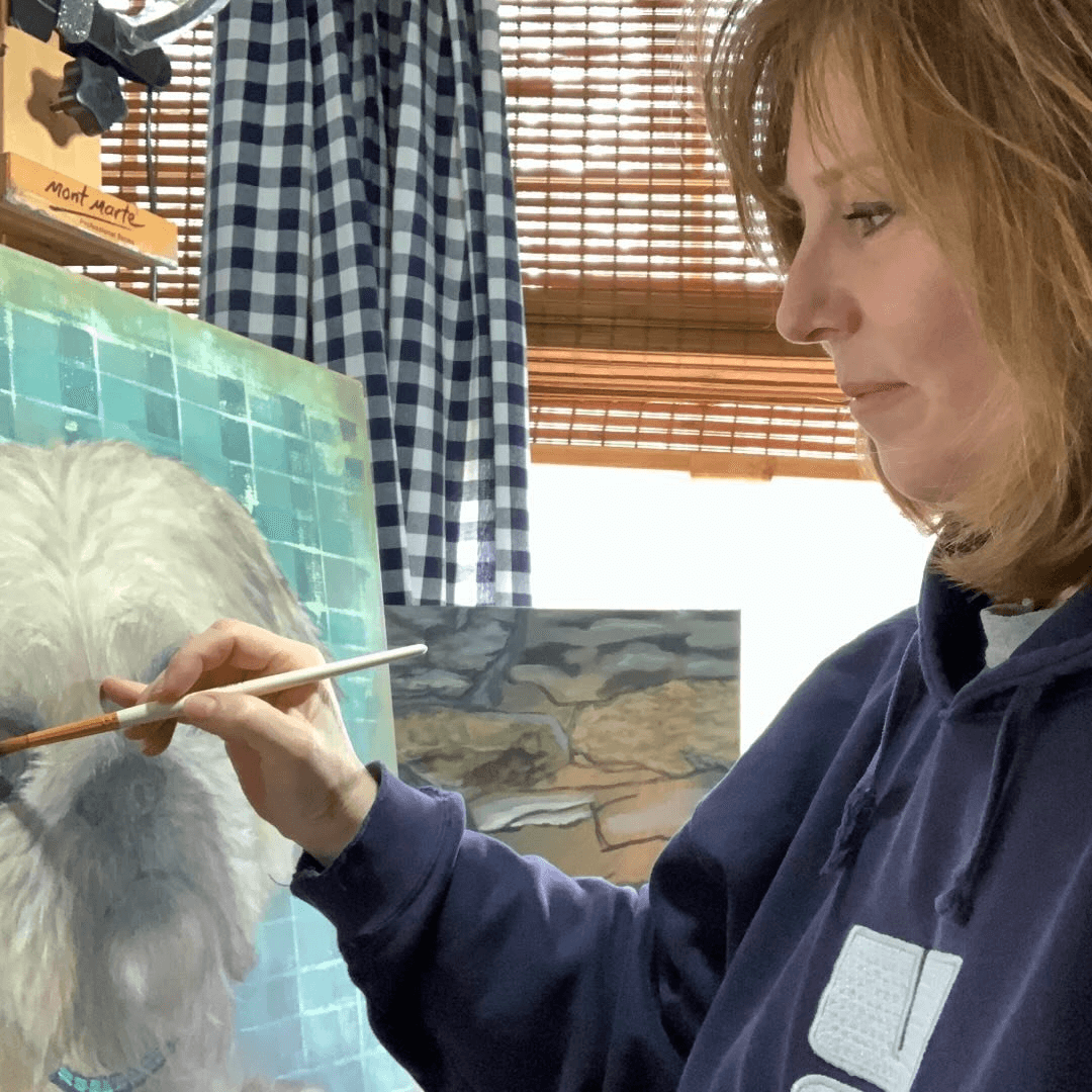 Barbara J Demers at her easel, painting a dog portrait in oil